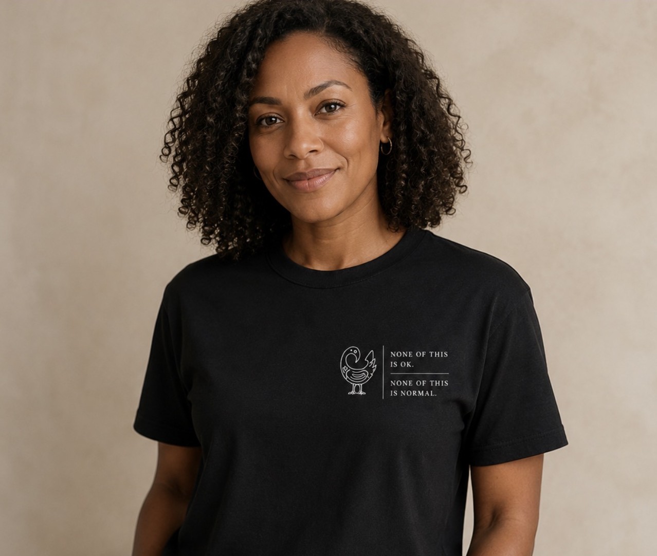 None Of This Is OK, Bird of Sankofa design on a black garment